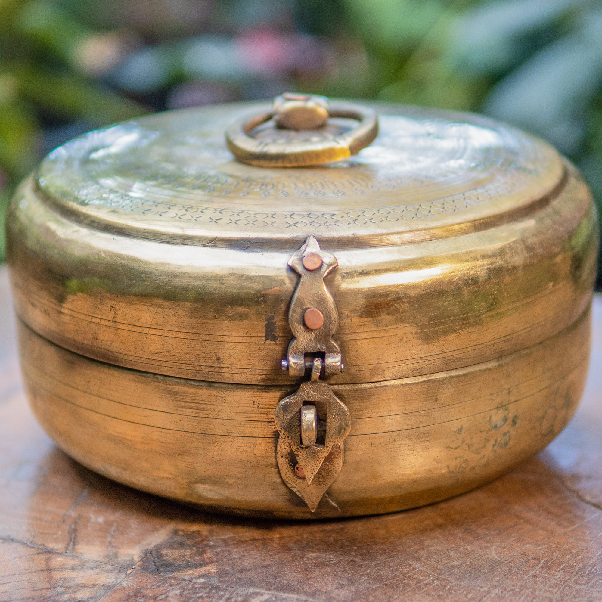 Brass box with decorative lock on a wooden surface