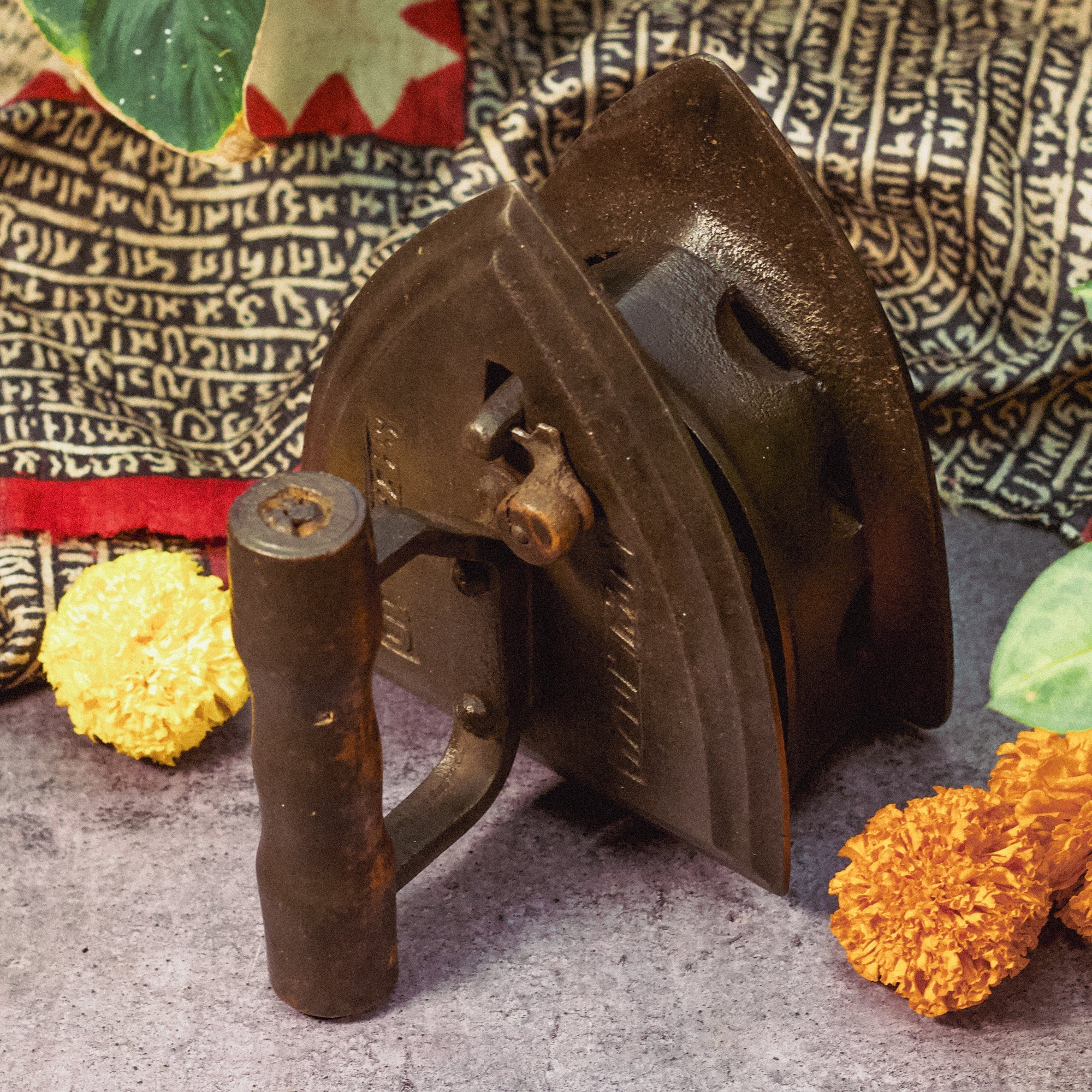 Vintage metal tool with floral decorations on a textured surface