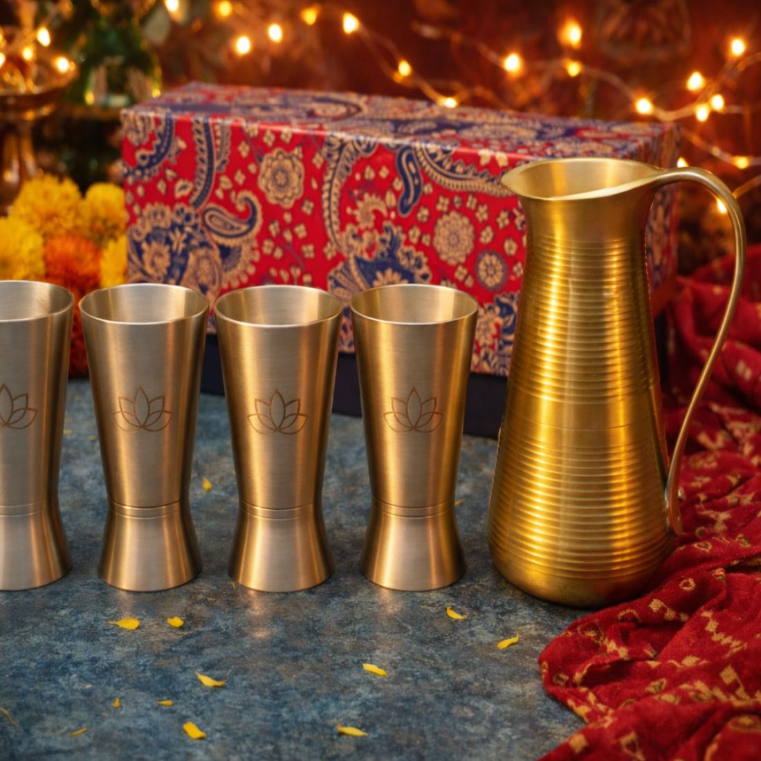 Set of metallic cups and a pitcher on a textured surface with decorative background