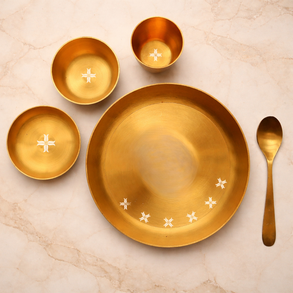 Set of gold ceramic dishes with decorative elements on a marble surface