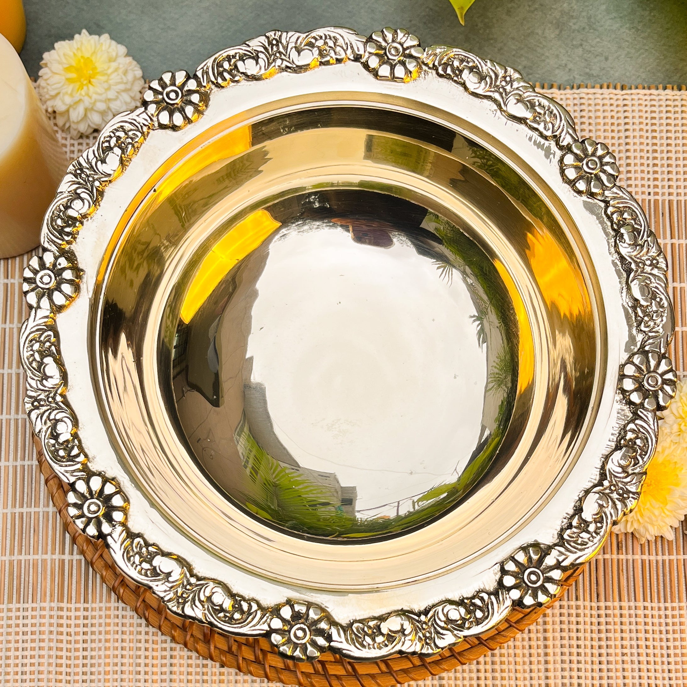Decorative metal plate with intricate designs on a woven mat.