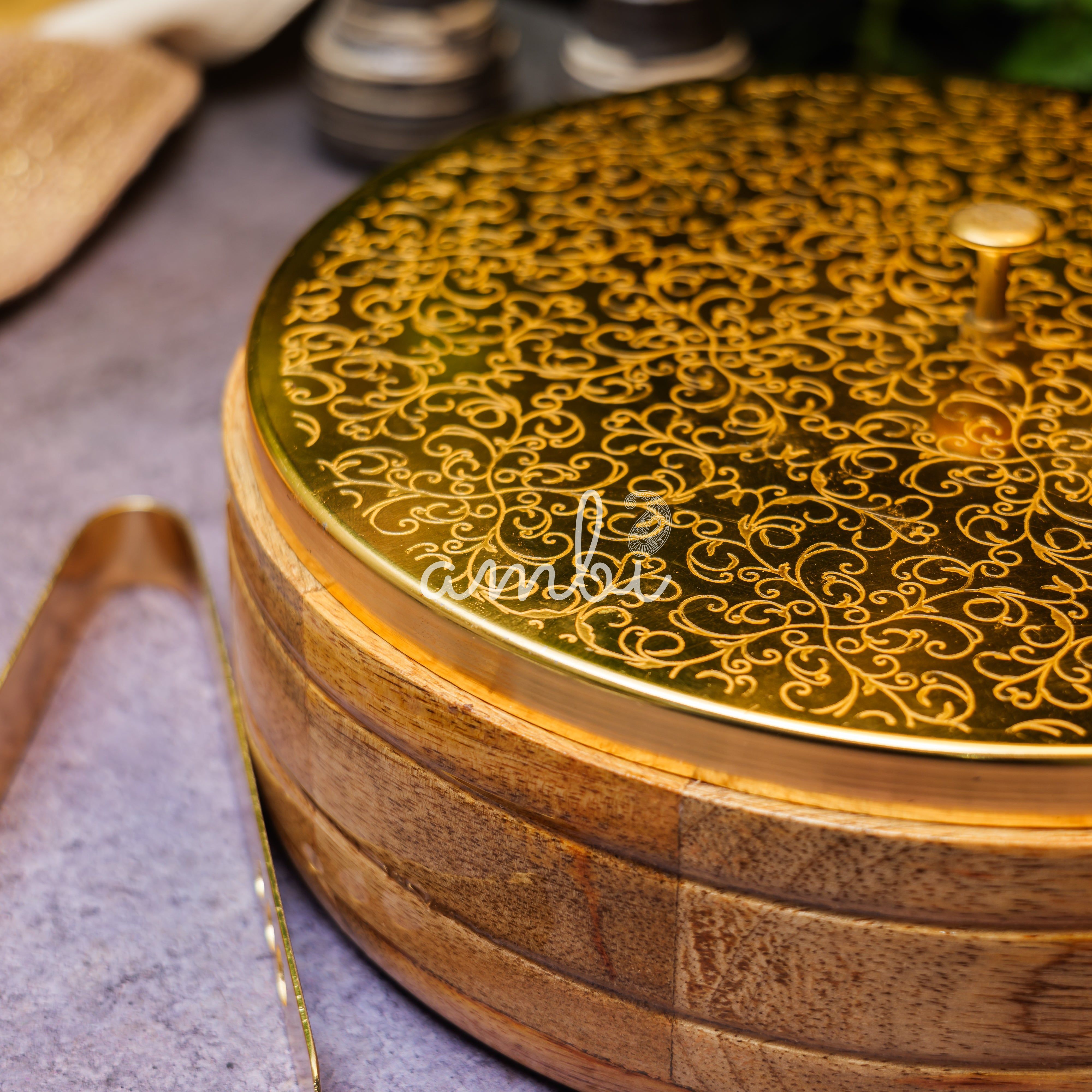 Intricately Etched Ambi Pure Brass Roti Box with Wooden Base and Tongs - 9 Inche