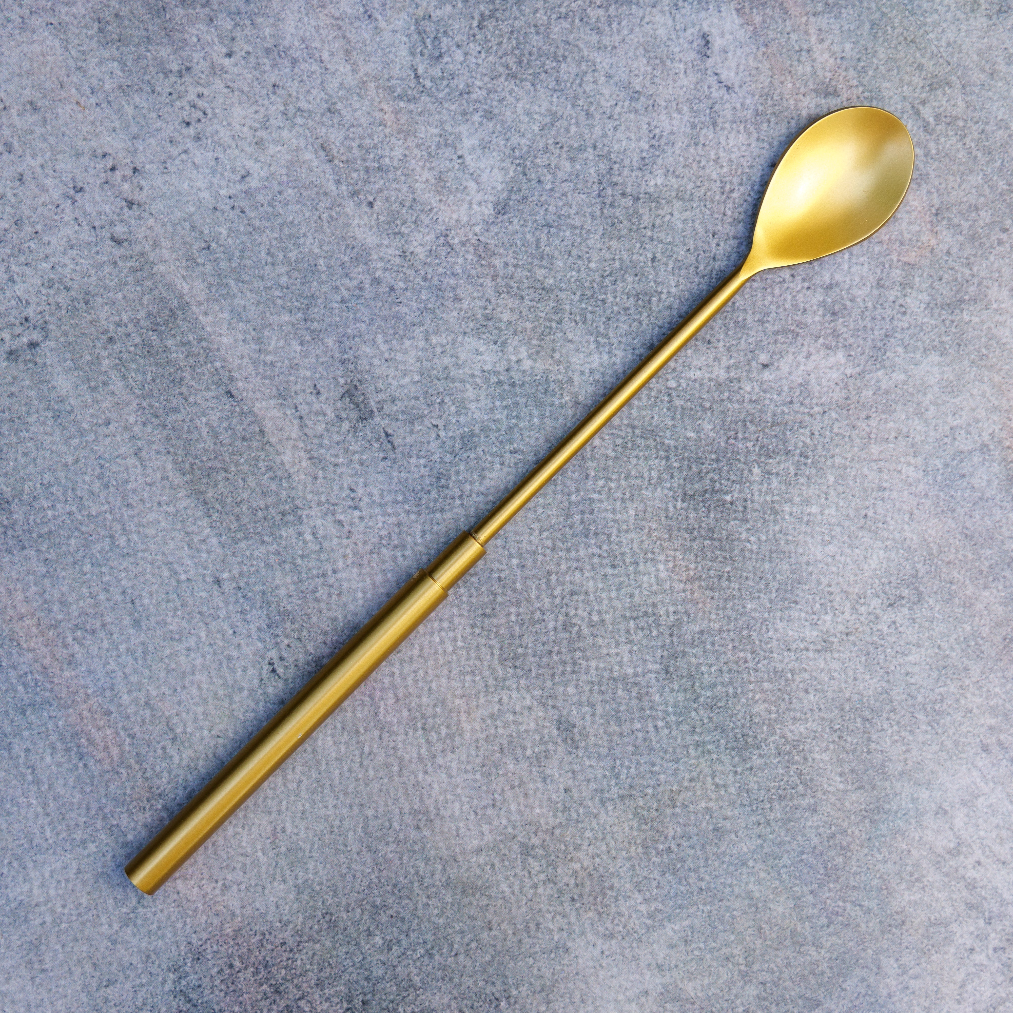 Gold spoon on a gray concrete surface