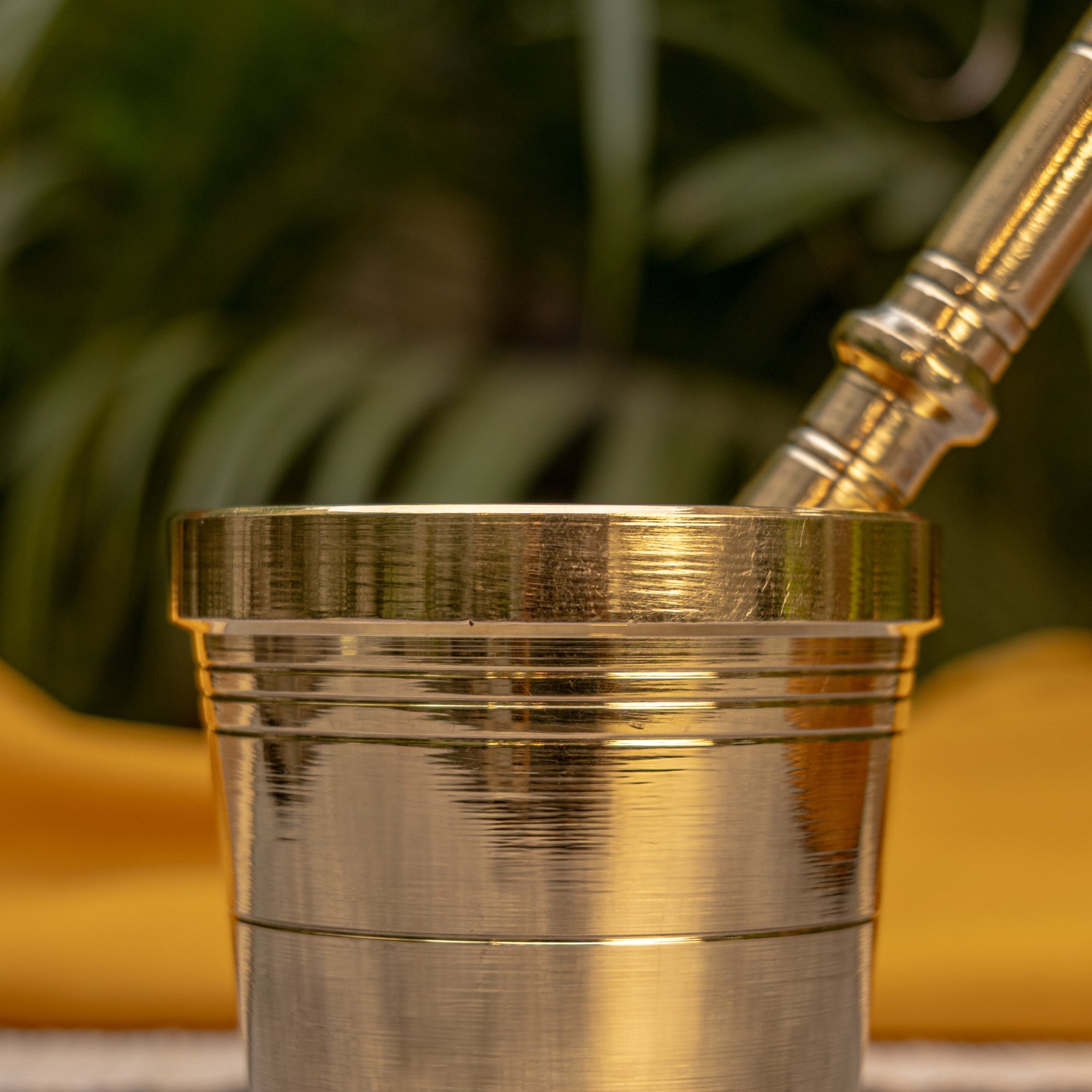 Close-up of a metallic object with a blurred green and yellow background