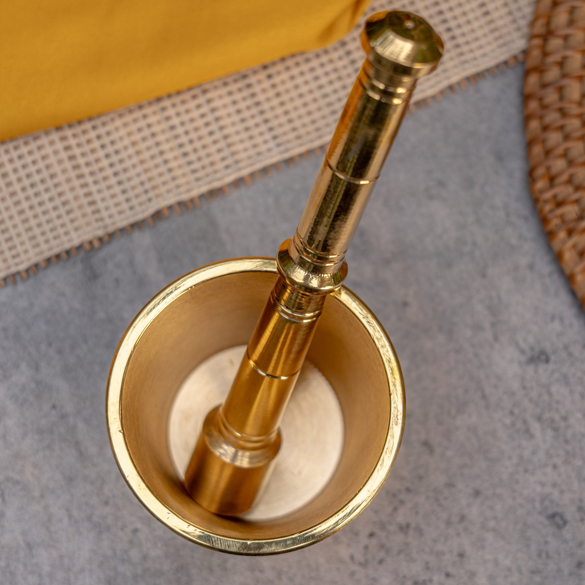 Brass mortar and pestle on a textured surface