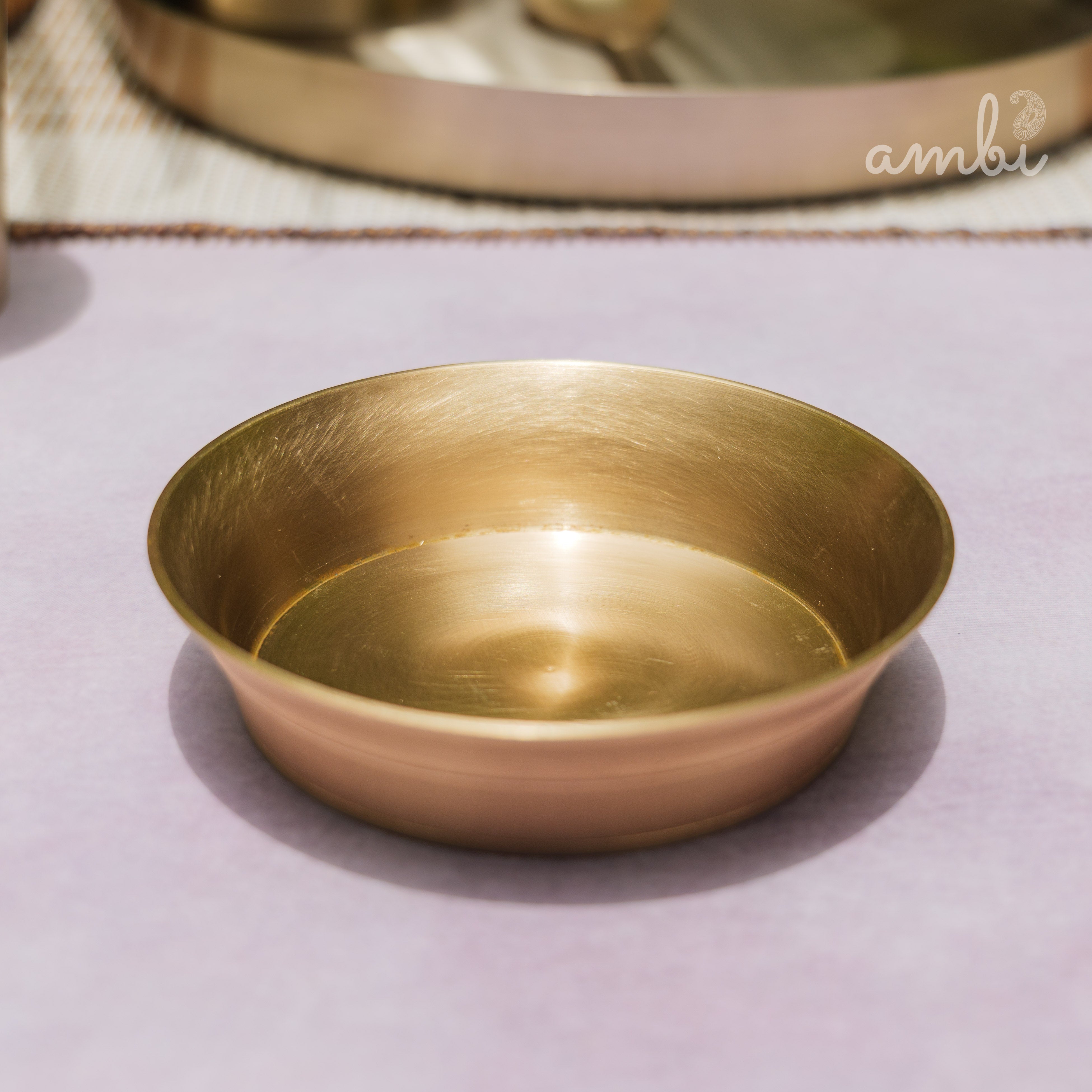 Gold bowl on a white surface with 'Ambi Home' text overlay