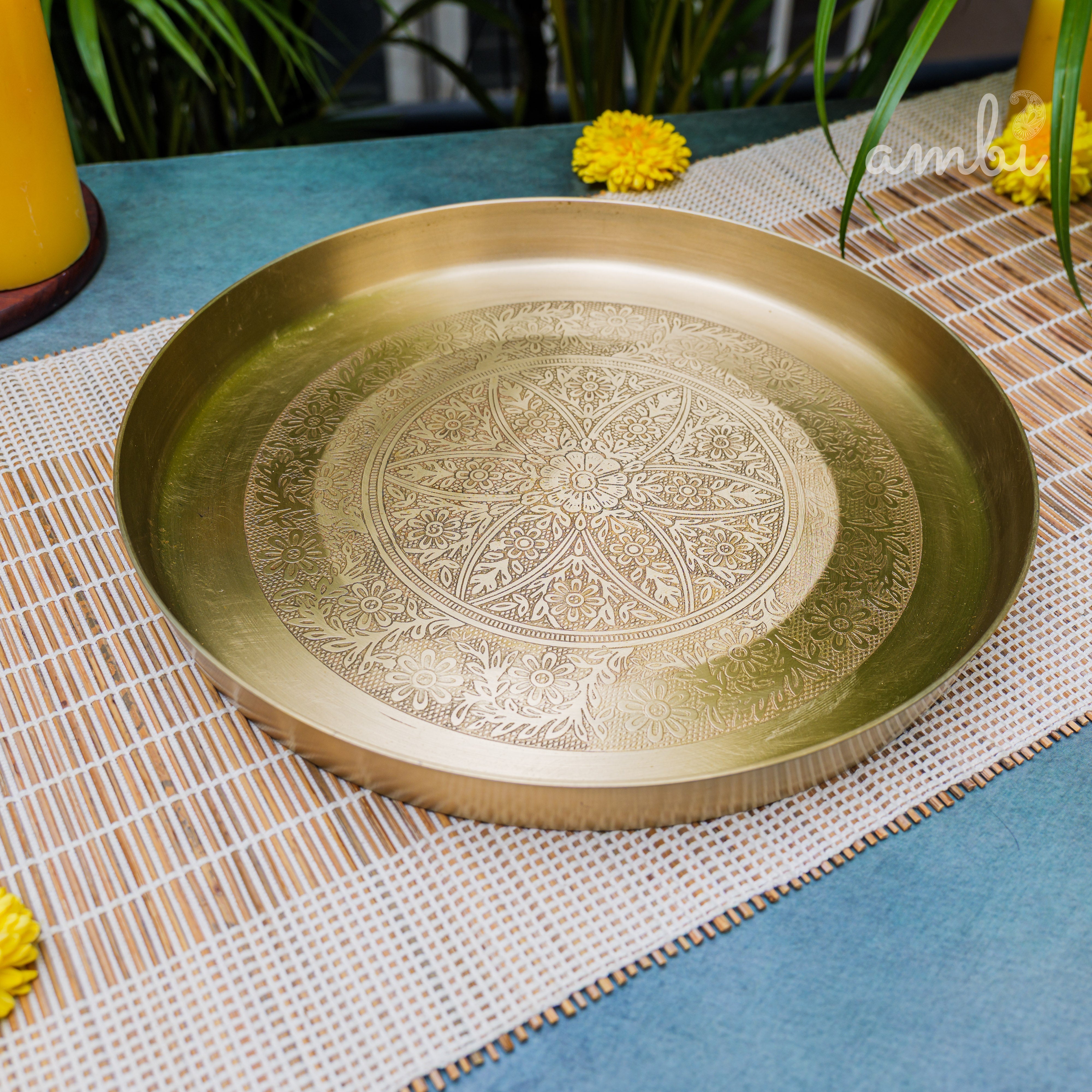 Decorative gold tray with intricate patterns on a table with a white and blue checkered tablecloth.